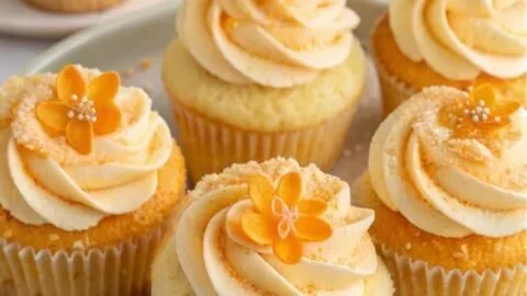 Delicious orange blossom cupcakes topped with creamy frosting