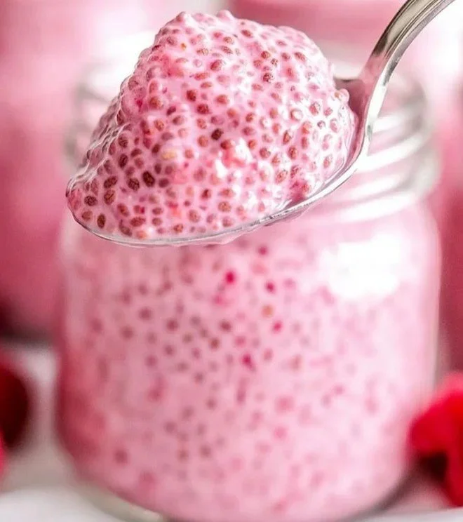 Delicious raspberry chia pudding in a glass topped with fresh raspberries